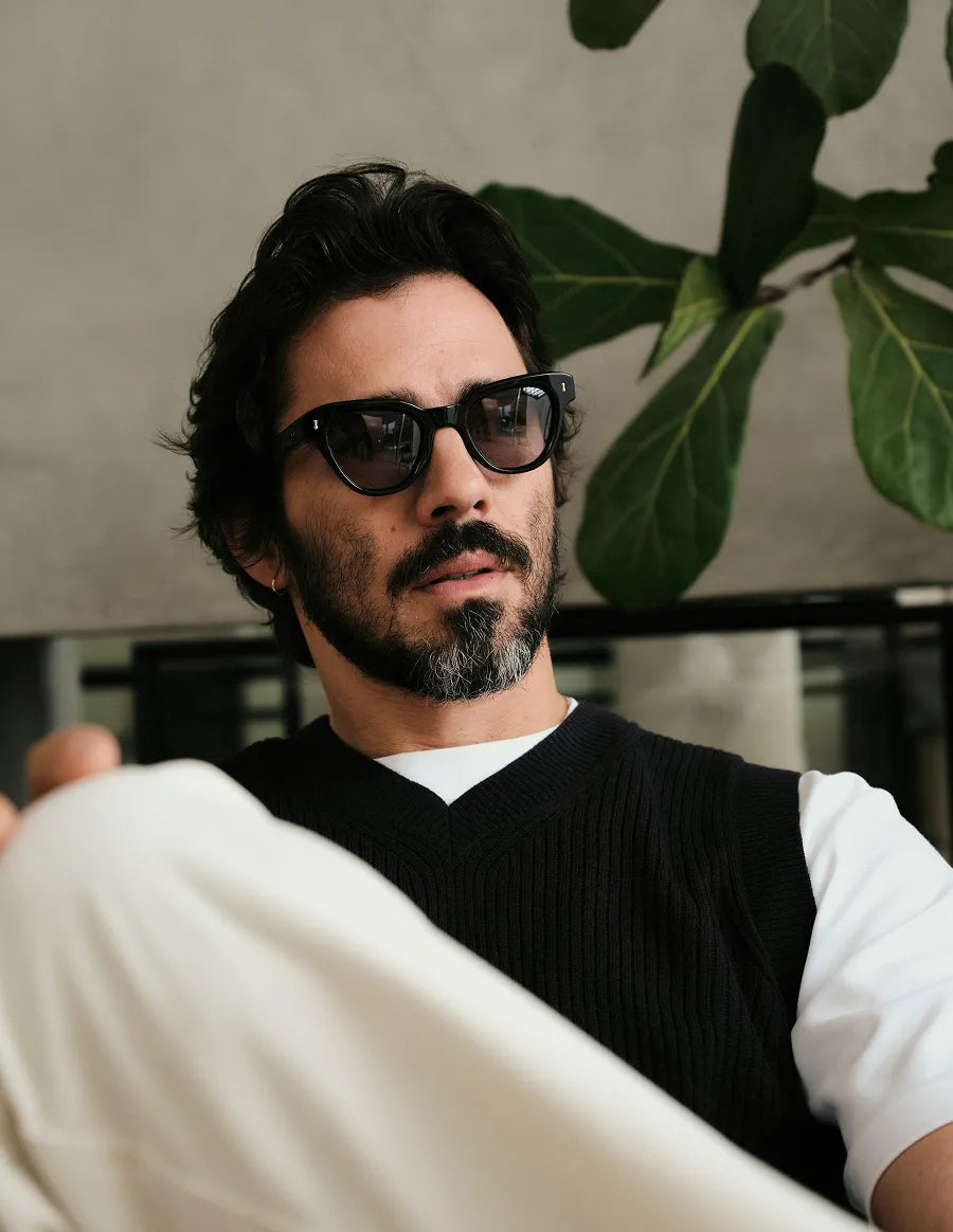 Man wearing black sunglasses with black lenses with a blurred background