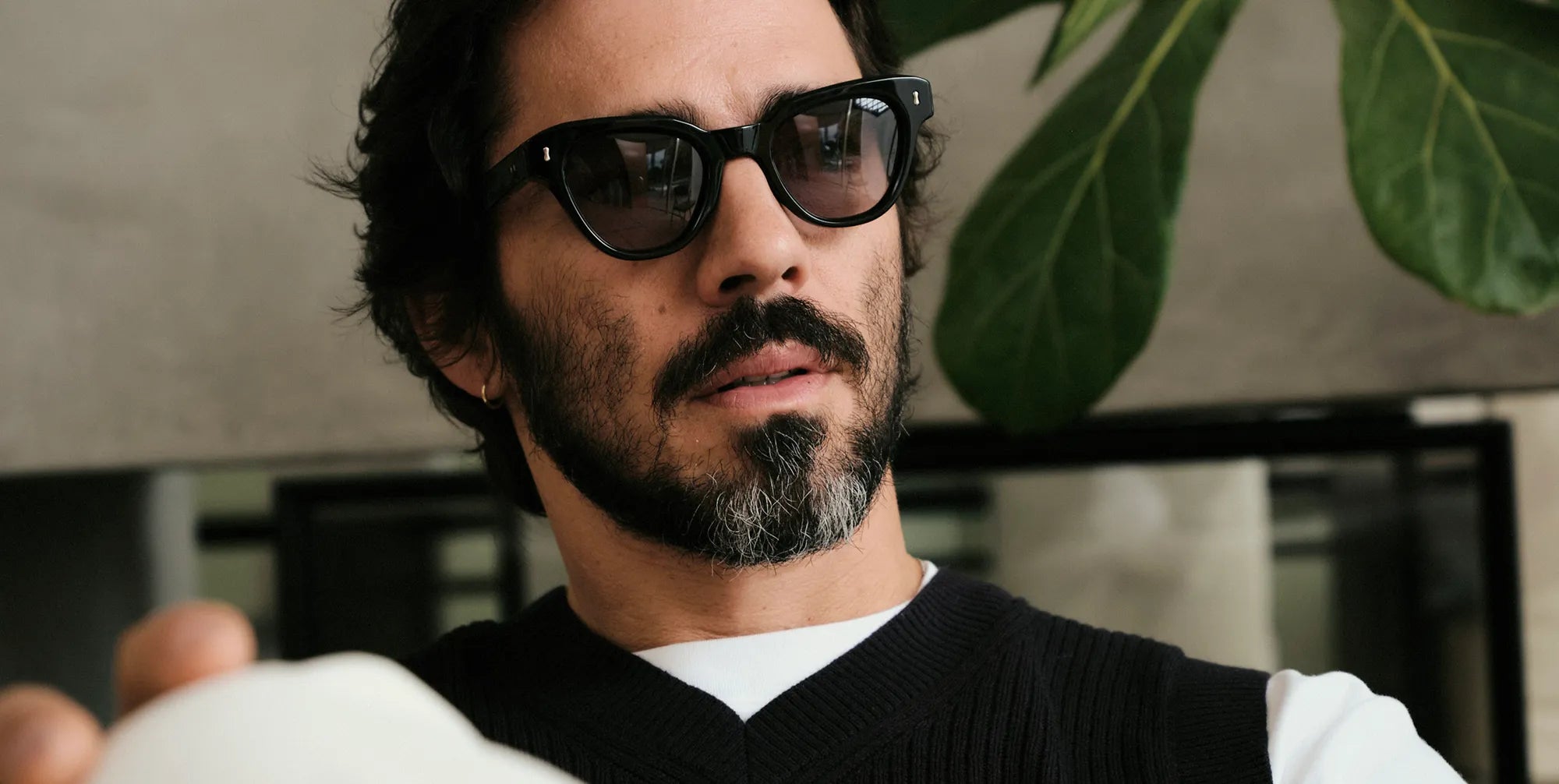 Man wearing black sunglasses with black lenses with a blurred background