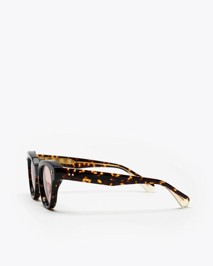 Tortoiseshell cat-eye sunglasses with brown lenses on a white background