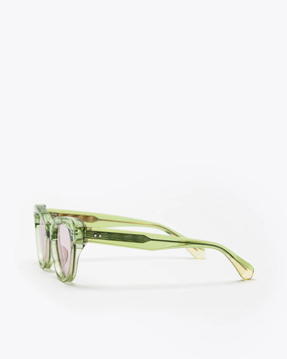 Seafoam green sunglasses with lilac lenses, sideways, on a white background