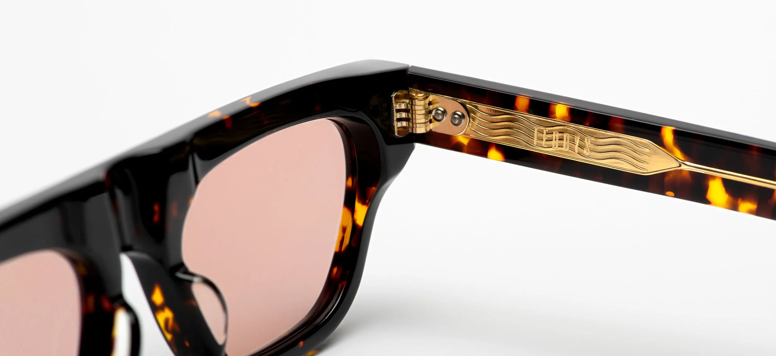 Sunglasses with tortoiseshell frame and brown lenses on a white background