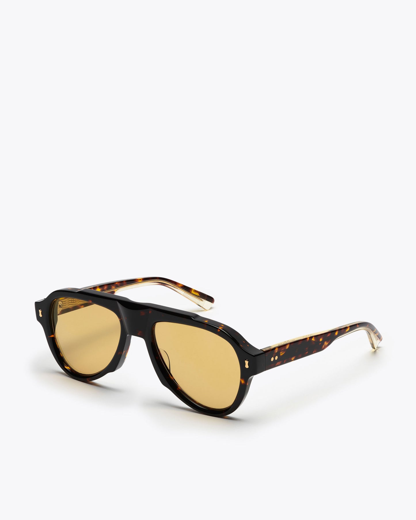 Sunglasses with tortoiseshell frame and amber lenses on a white background